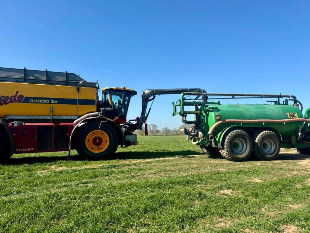 Tractor and tank trailer on grass field.